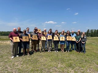  A group of people holding award plaques.